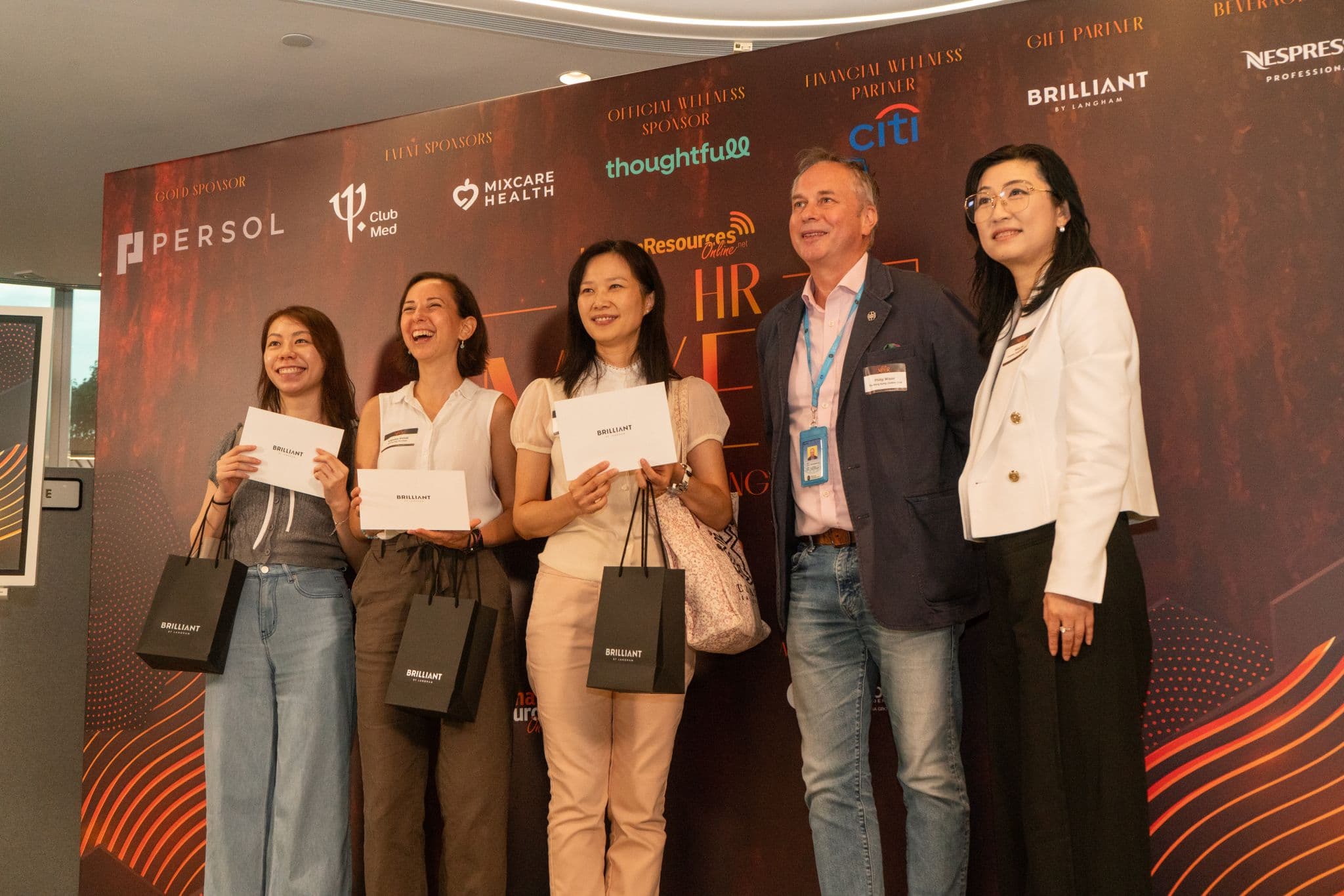 Guests and hosts smiling together during a prize presentation