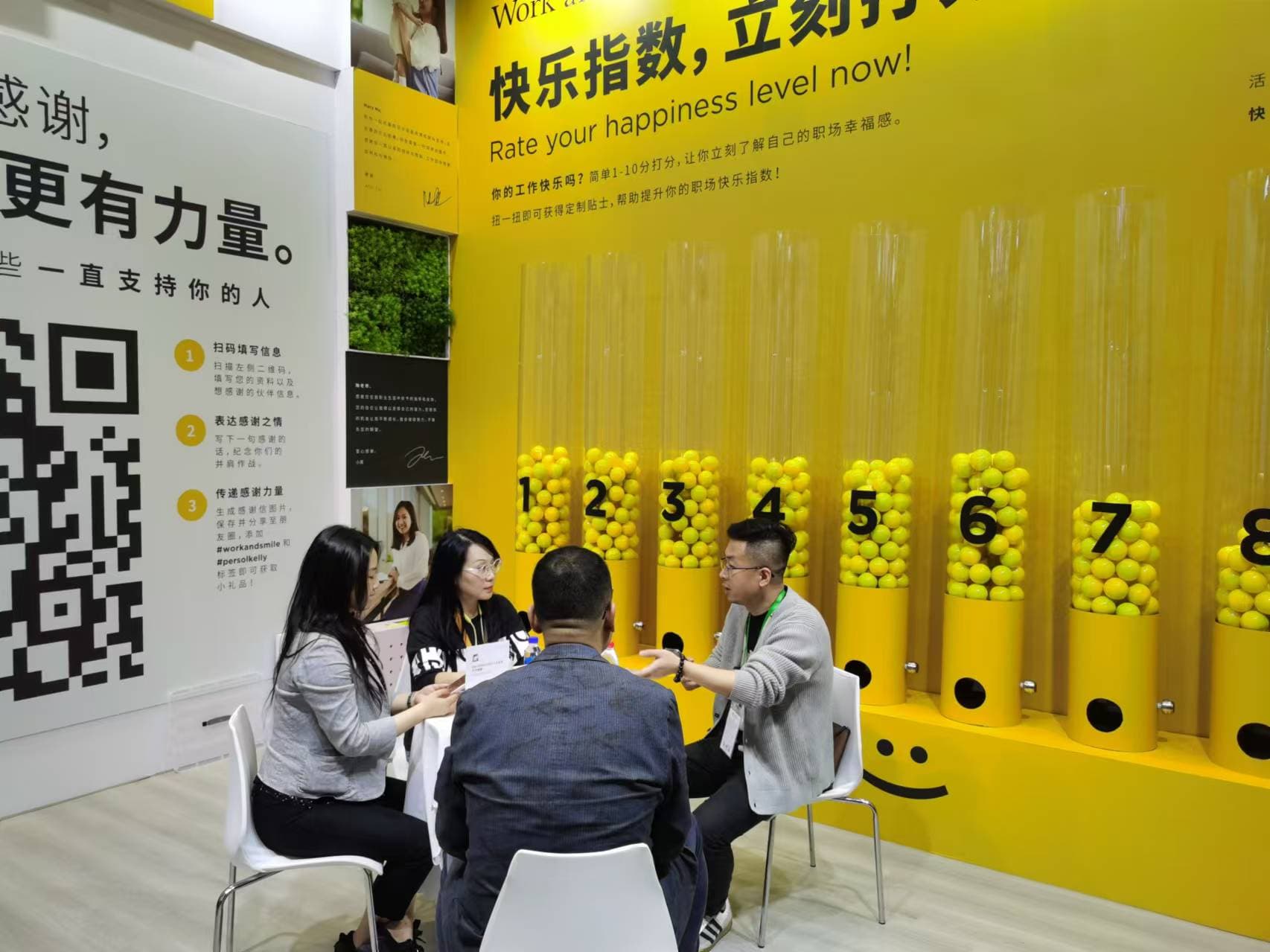 Visitors seated at the PERSOL booth with the activation behind them