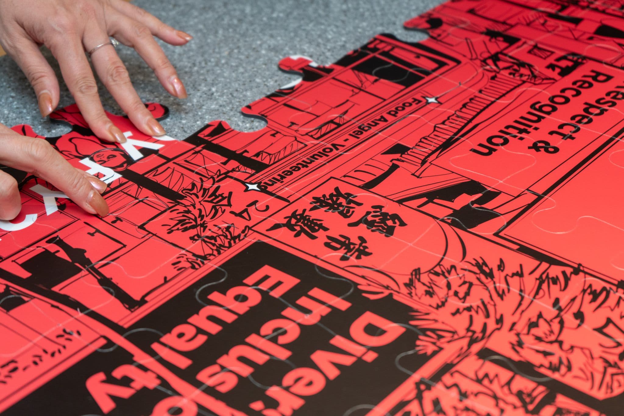 Hands placing a puzzle piece into the red campaign artwork